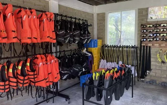 Life jackets, snorkel gear on racks in storage room.